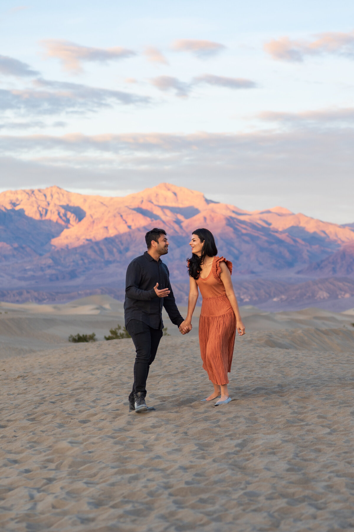 A couple holding hands and laughing as they walk together