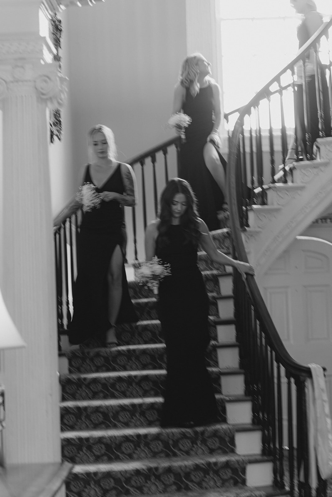 bridesmaids_come_down_stairs_black_and_white_candid_wedding_moment_thomas_bennett_house_curved_staircase_kailee_dimeglio_photography-607_websize