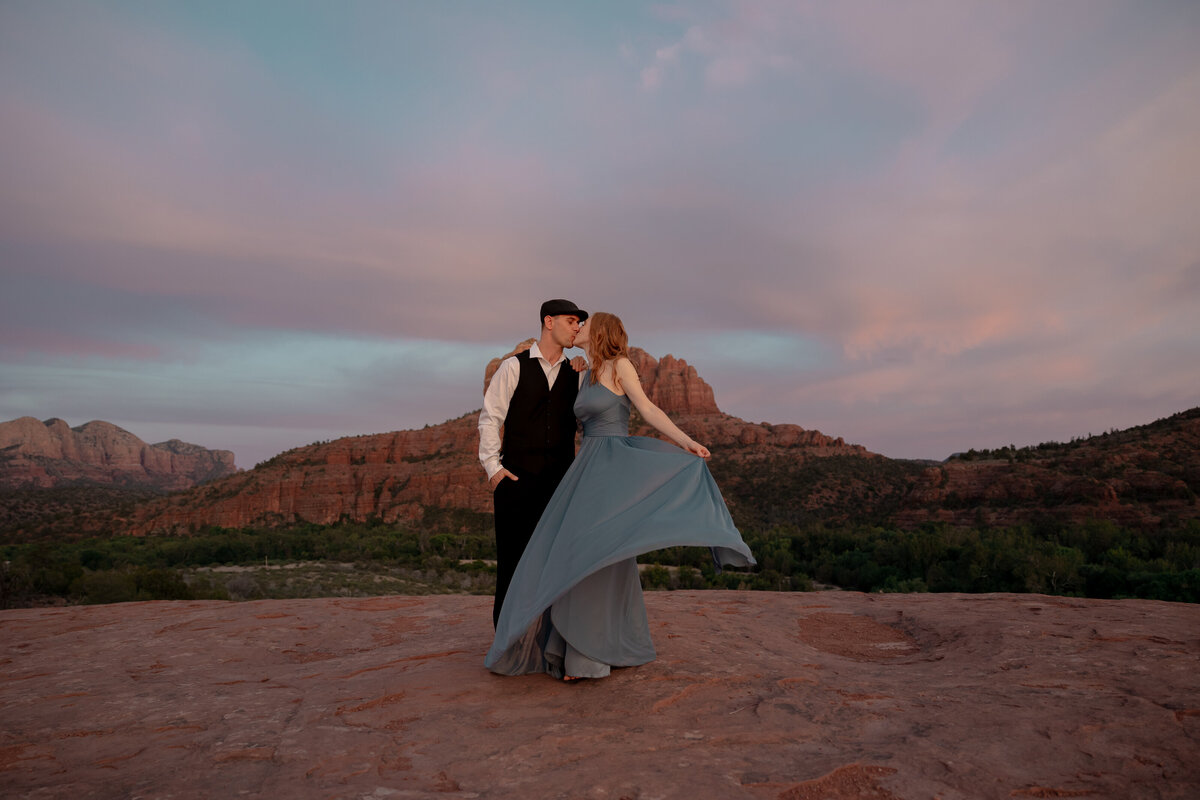 Couple standing against red rock backdrop during Sedona engagement session