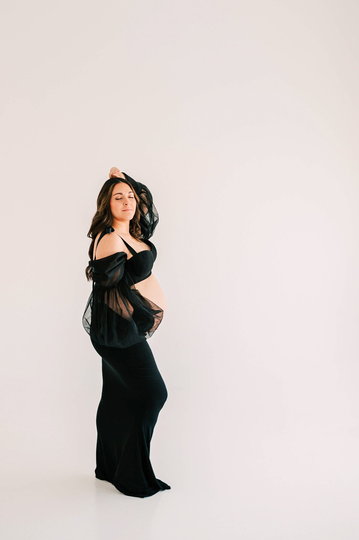 pregnant mom closing eyes in studio enjoy maternity photography in Springfield MO