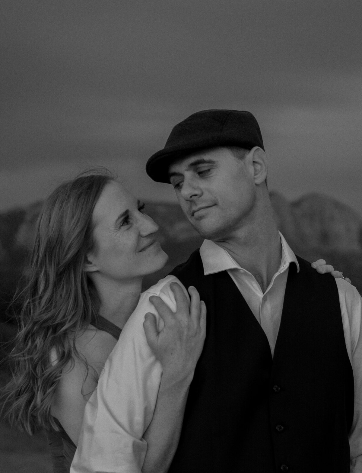 Couple standing against red rock backdrop during Sedona engagement session