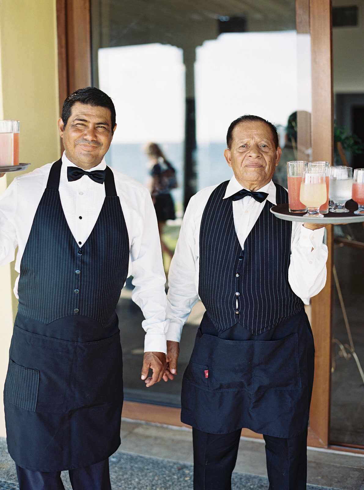 waiters carrying trays with cocktails on them