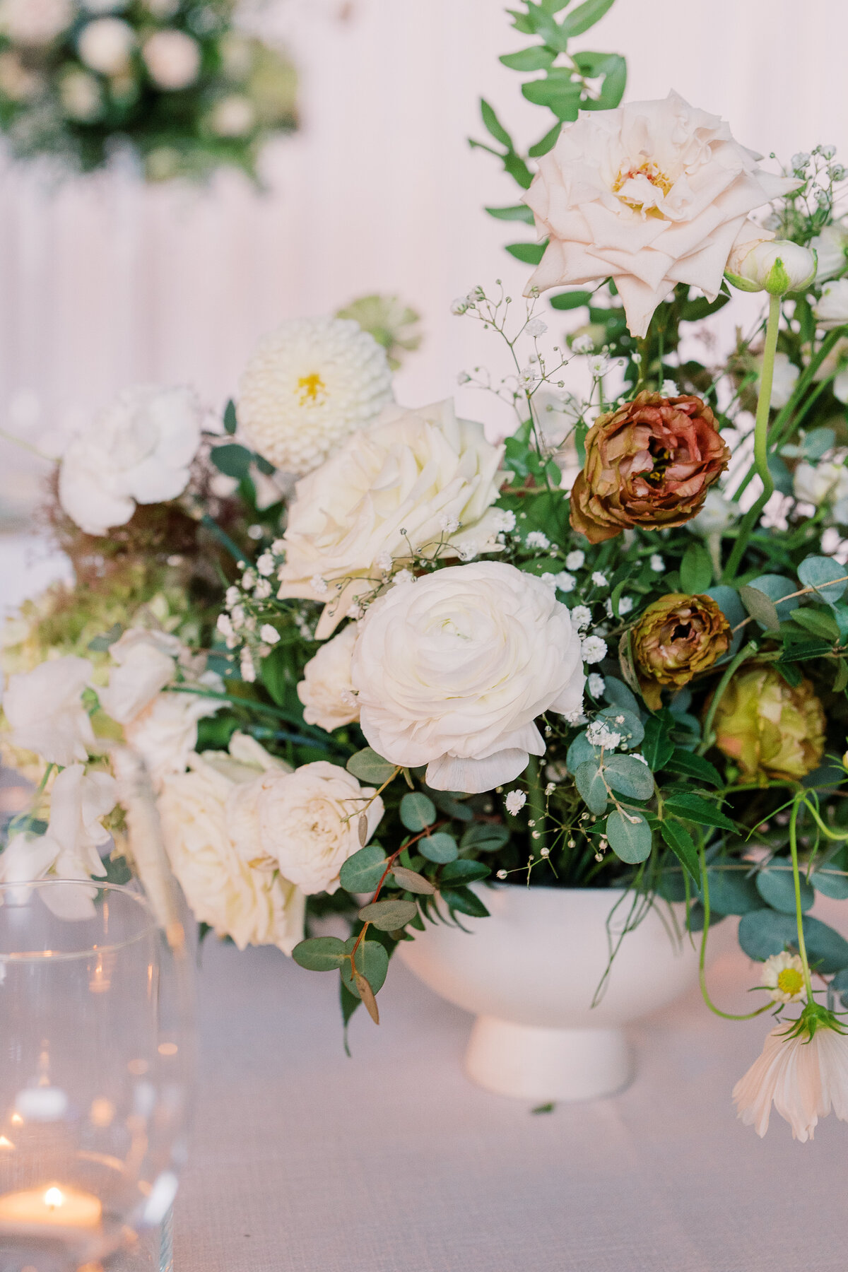 Lush low centerpieces for timeless garden wedding in downtown Nashville. Summer wedding florals in colors of white, cream, green, and taupe. Summer floral design full of roses, ranunculus, hydrangea, cosmos, and lisianthis. Design by Rosemary & Finch Floral Design in Nashville, TN.