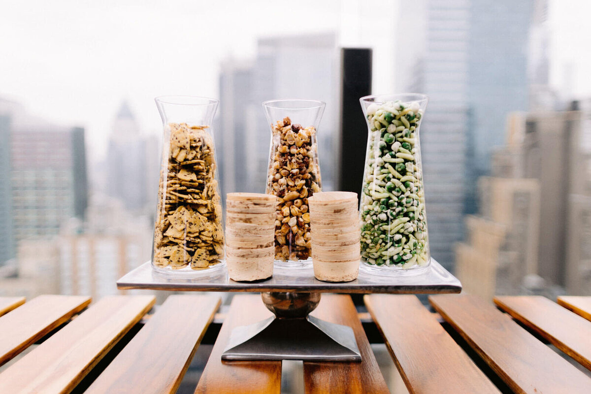 Three large, clear vases filled with biscuits, nuts, and candies in The Skylark, New York. Wedding Image by Jenny Fu Studio