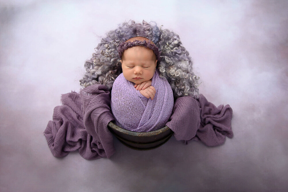 newborn girl wrapped in purple for her newborn photography session in Hamilton, Ontario.