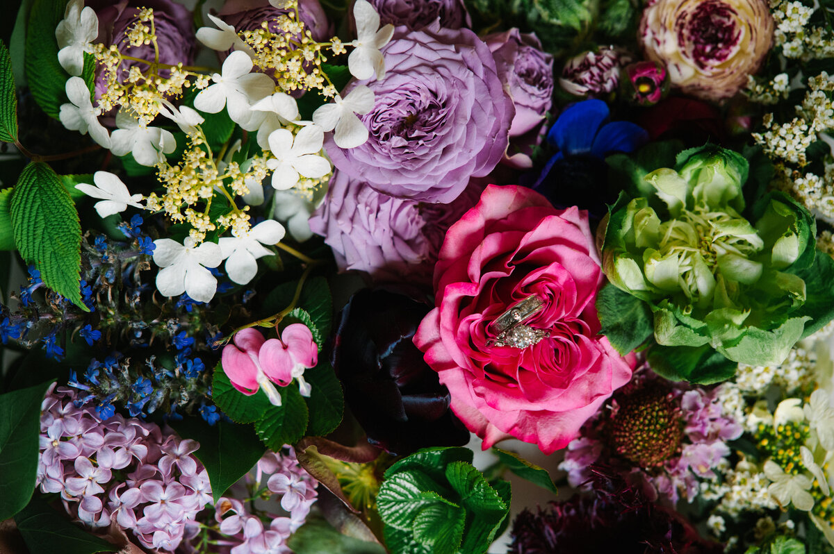 Close up of wedding rings in flower arrangement