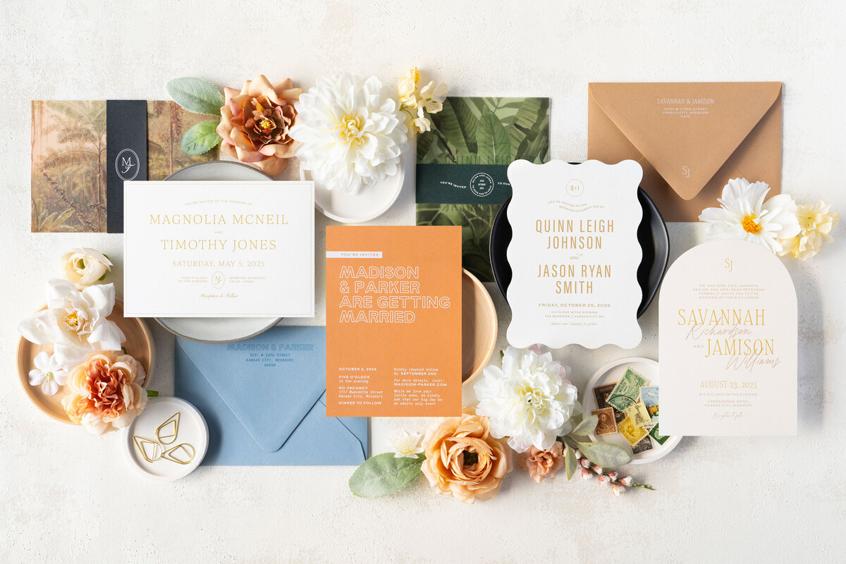 White wedding invitations with sage green envelopes and antique stamps
