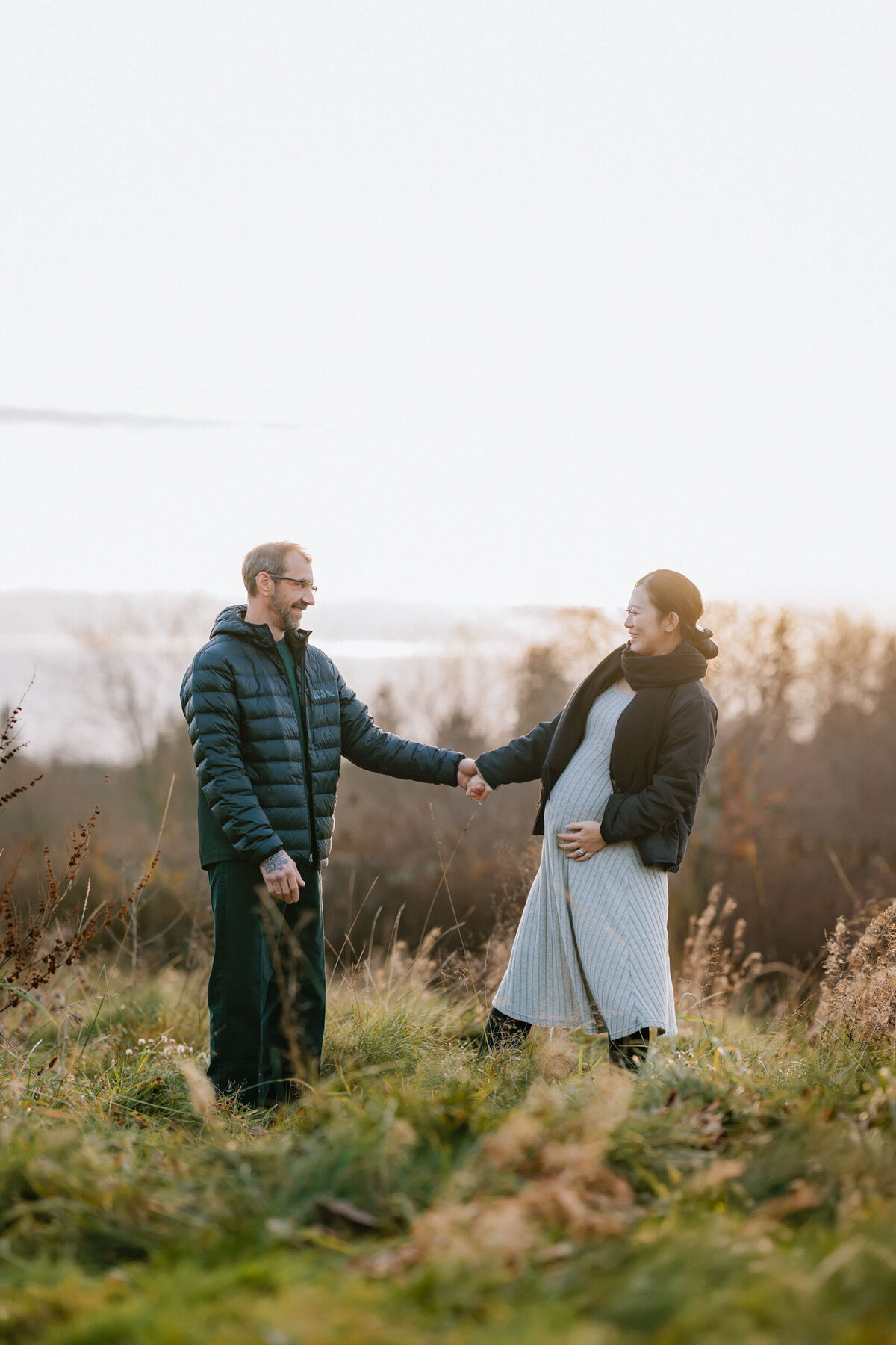 Pregnant couple dancing together, laughing and enjoying the joy of their growing family in a joyful maternity session.