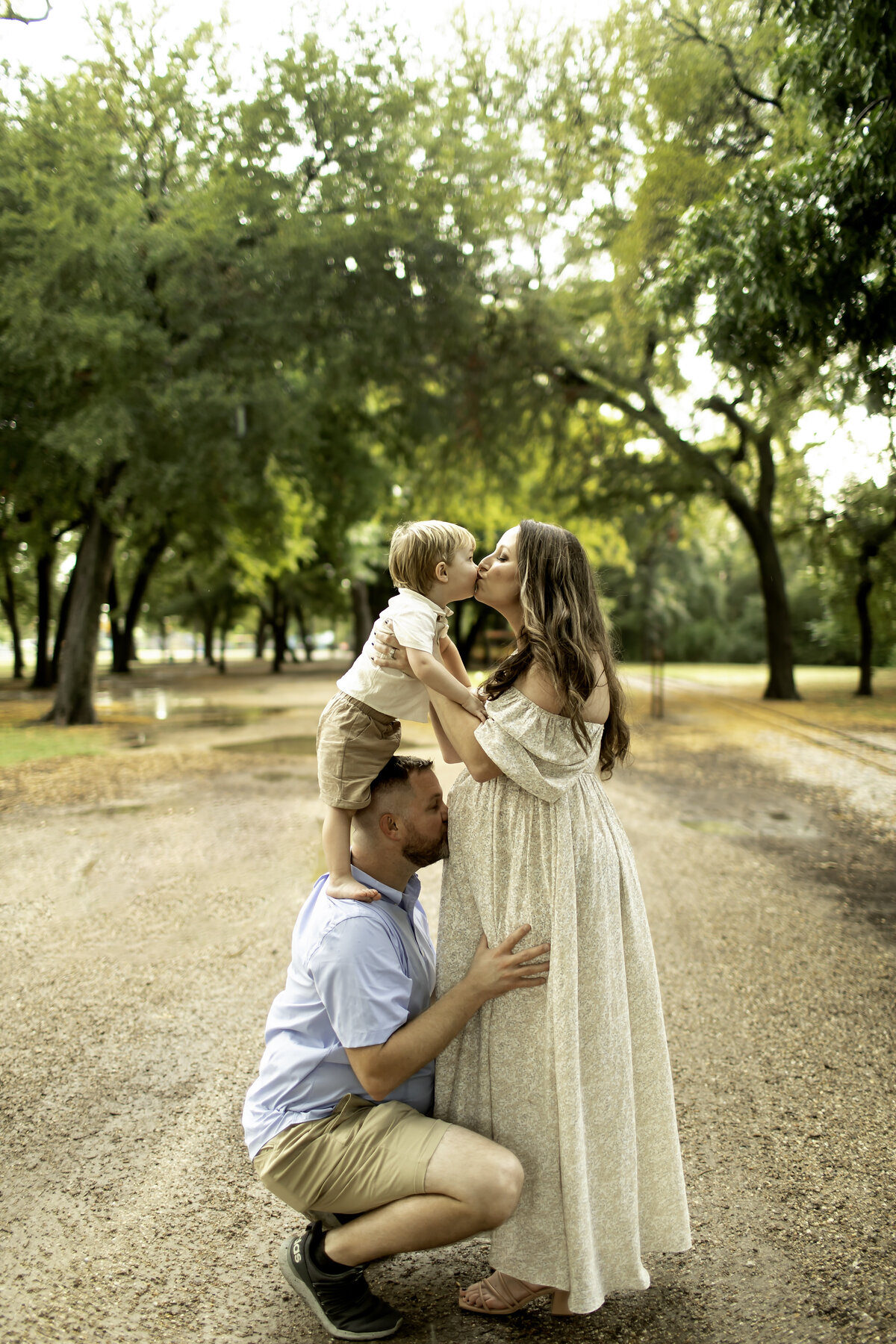 A romantic maternity photo of mom and dad standing together at Trinity Park, holding hands and sharing a loving gaze, captured by Chunky Monkey Photography.