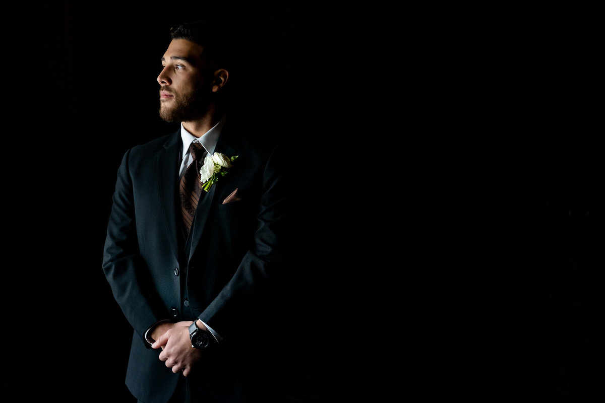 Photo of groom by the window at Rosewood Hotel Georgia.