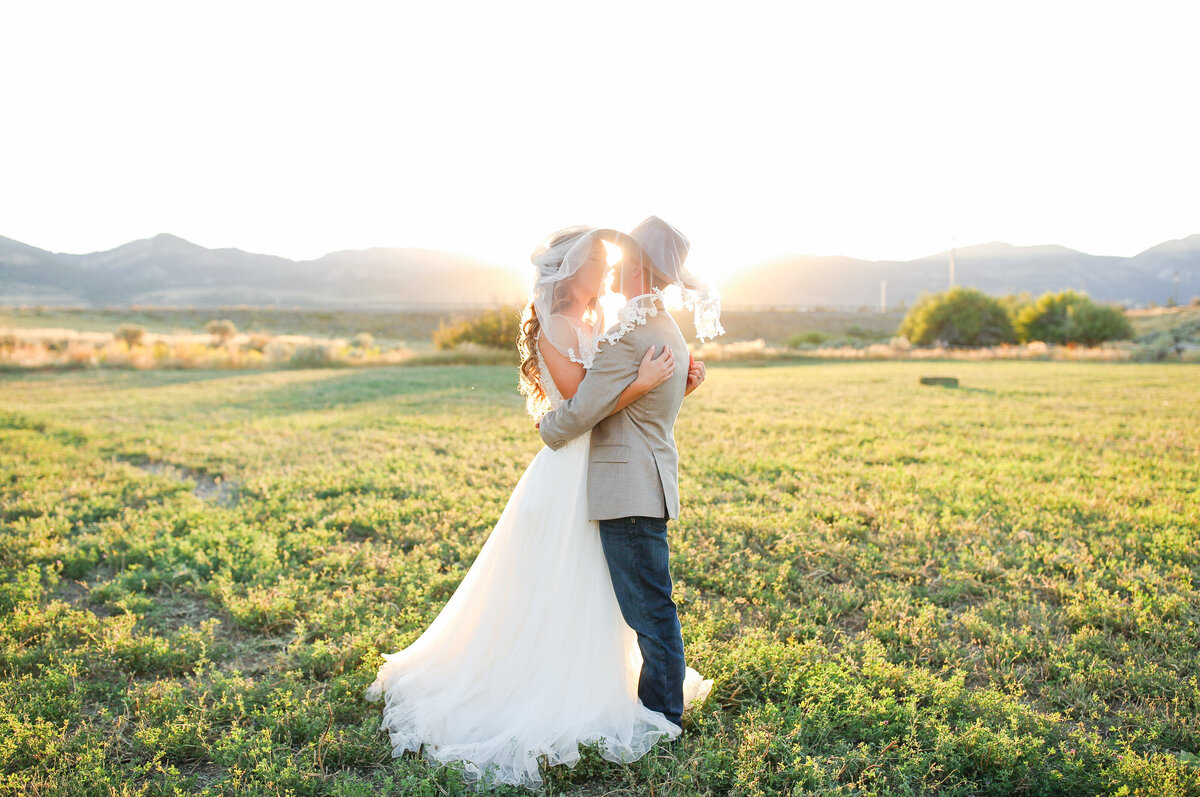 Country sunset wedding picture of a couple holding in a romantic embrace.