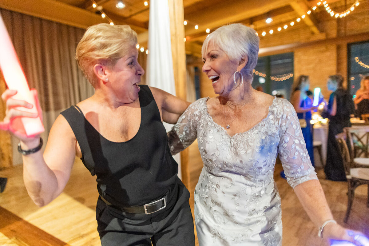Two women are standing next to each other and laughing