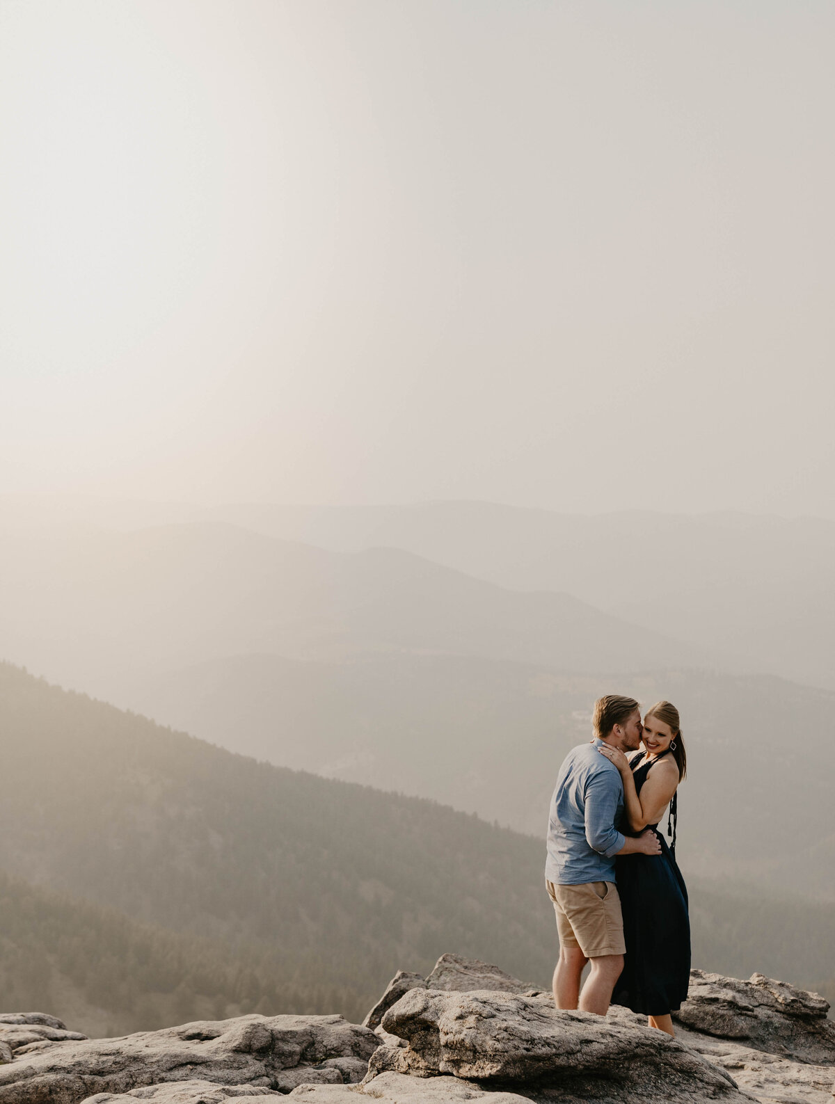 Boy kissing girl on mountain top in Boulder Colorado