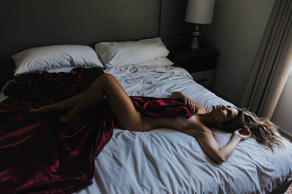 Woman laying on a bed during her boudoir shoot