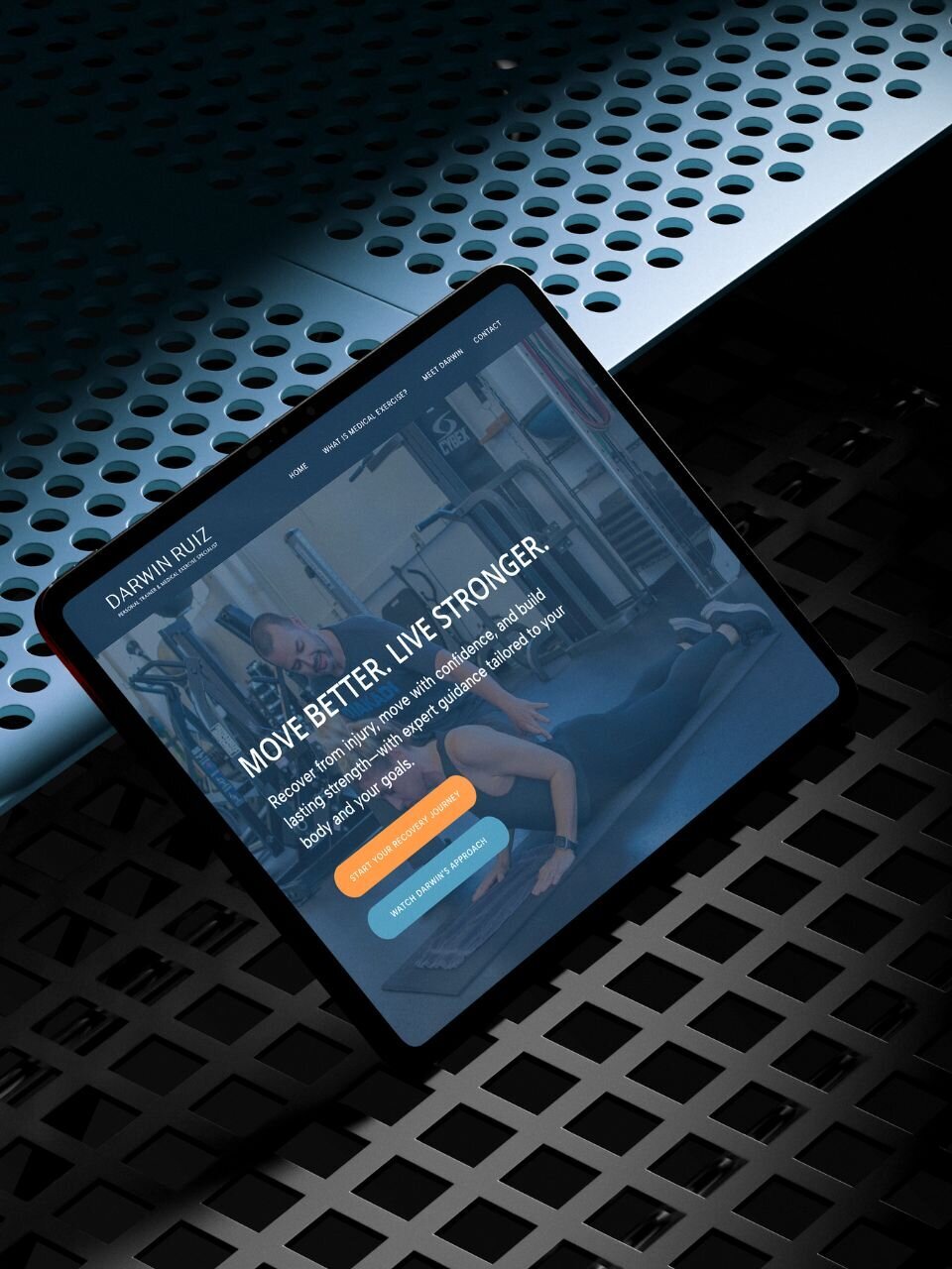 iPad displaying Darwin Ruiz’s homepage featuring the tagline “Move Better. Live Stronger.” and buttons for a recovery session and approach video, shown on a metallic perforated background.