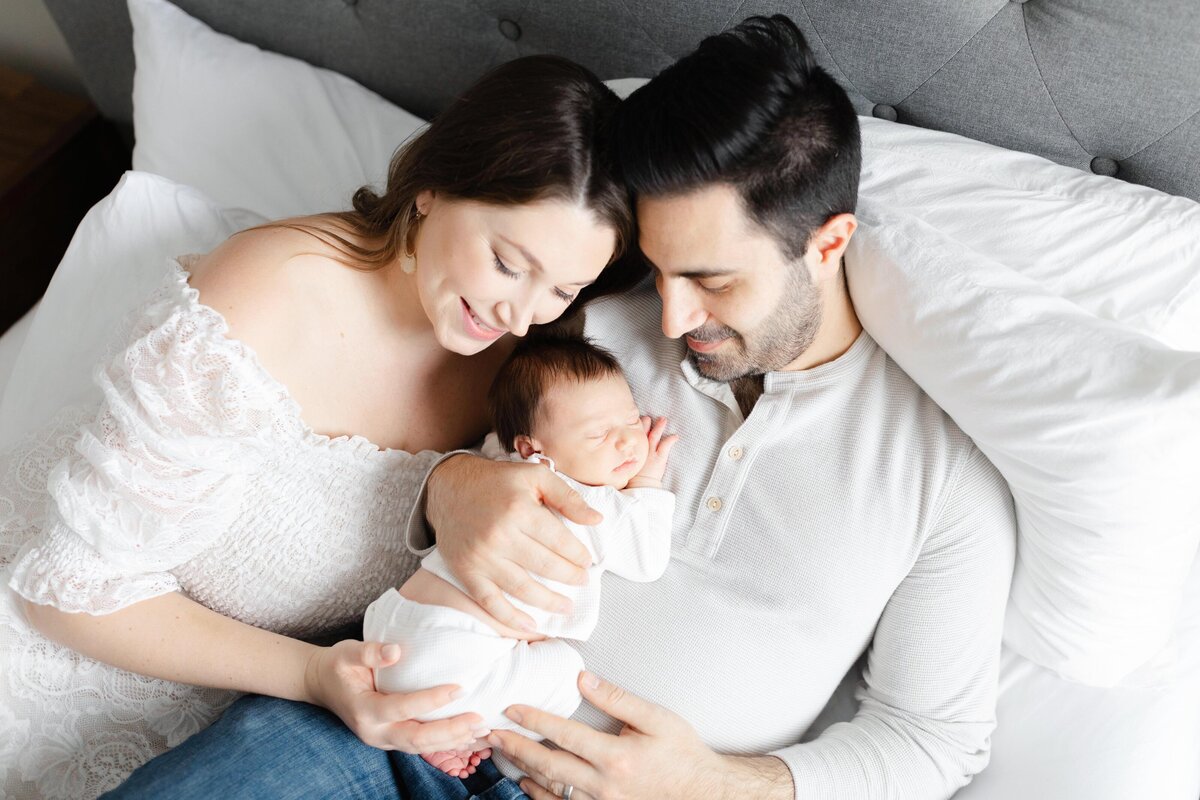 overhead shot of family laying in bed cuddling by Northern Virginia Family Photographer
