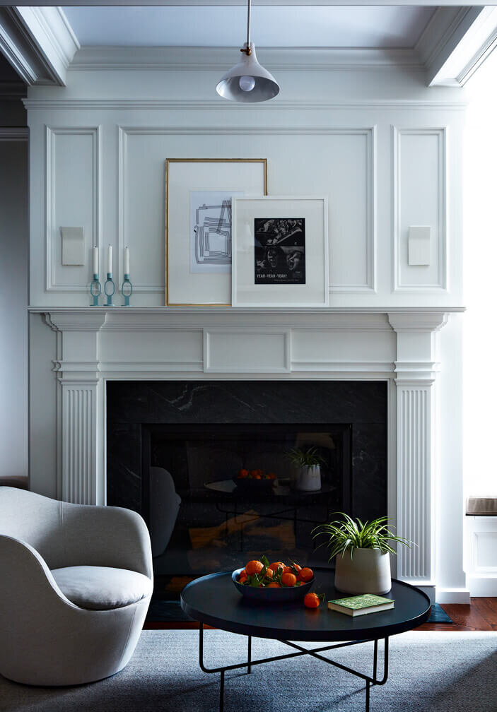 Interior decorators in Boston blend a traditional fireplace design with modern furniture, creating a refined balance of classic and contemporary style.