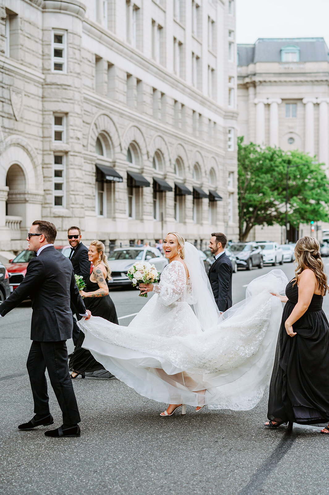 Groom holds brides dress as the walk through streets of downtown DC