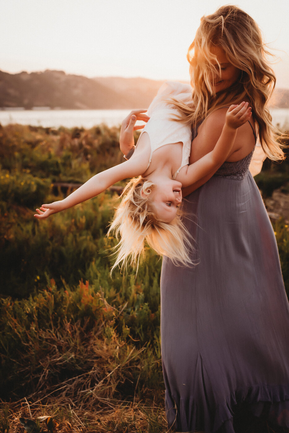 Sweet mother swinging her daughter back and forth at the Martinez Marina