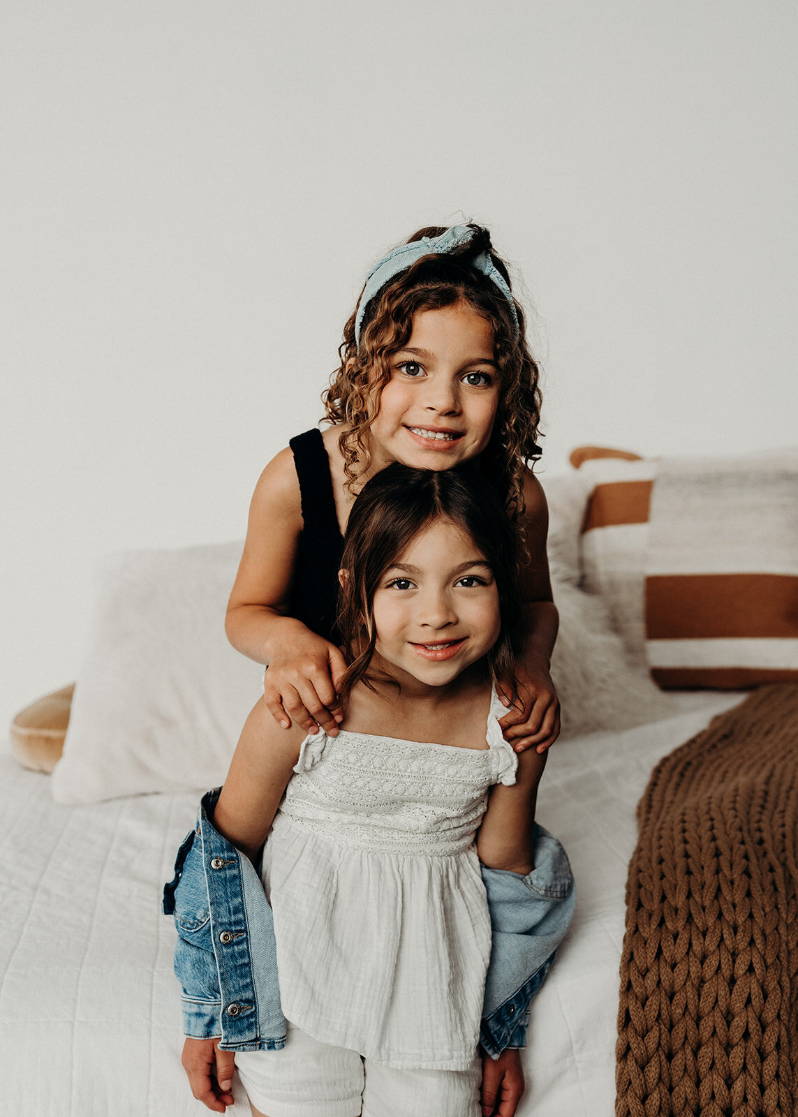 two sisters playfully smile at camera