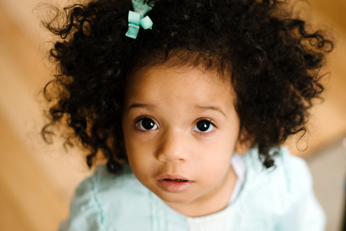 A small child with curly hair looking up.
