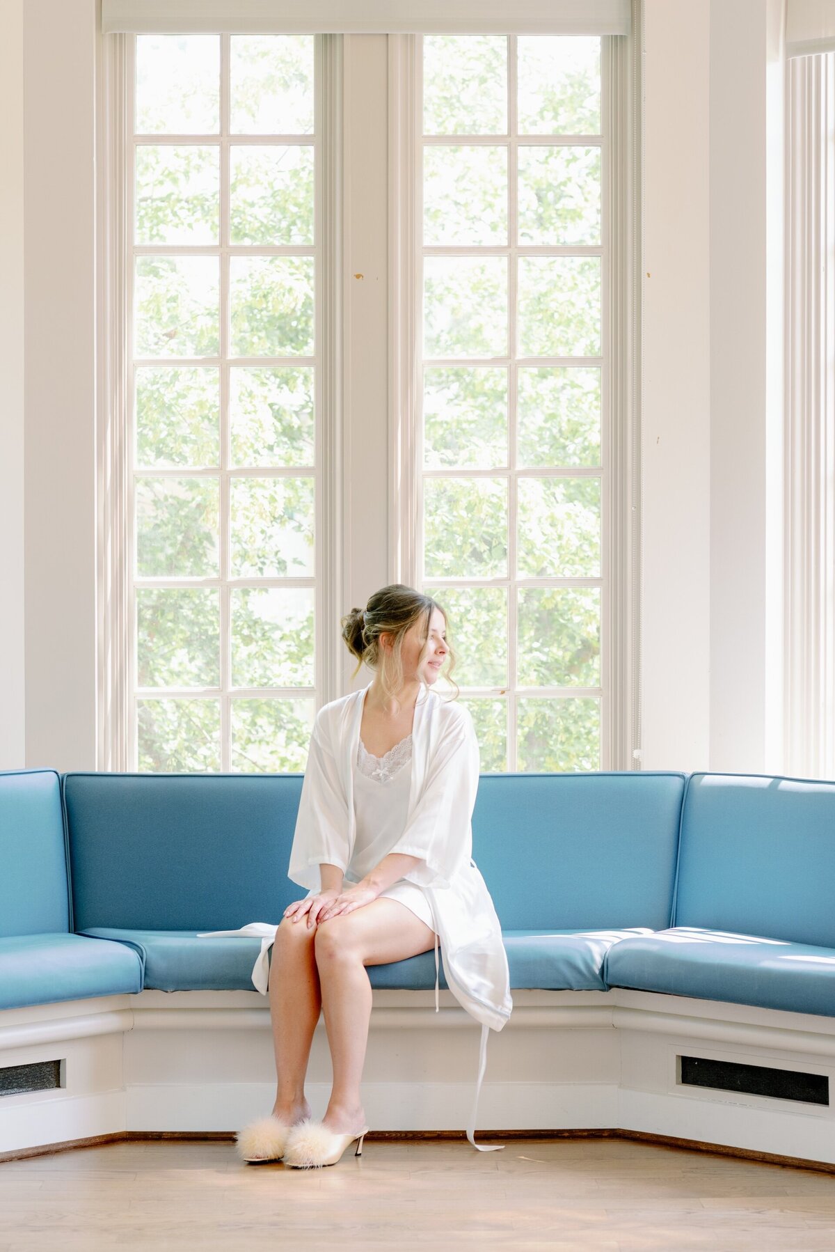 a bride in white pajamas sitting on a blue bench