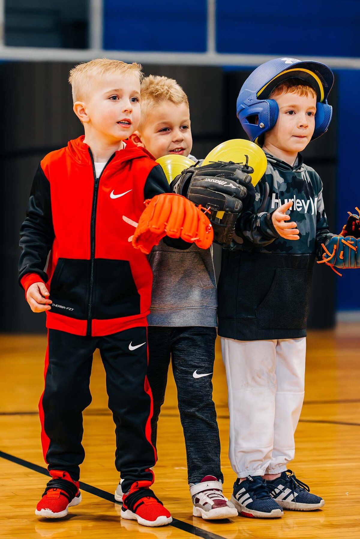 Little boys with catcher's mitts at tee ball practice