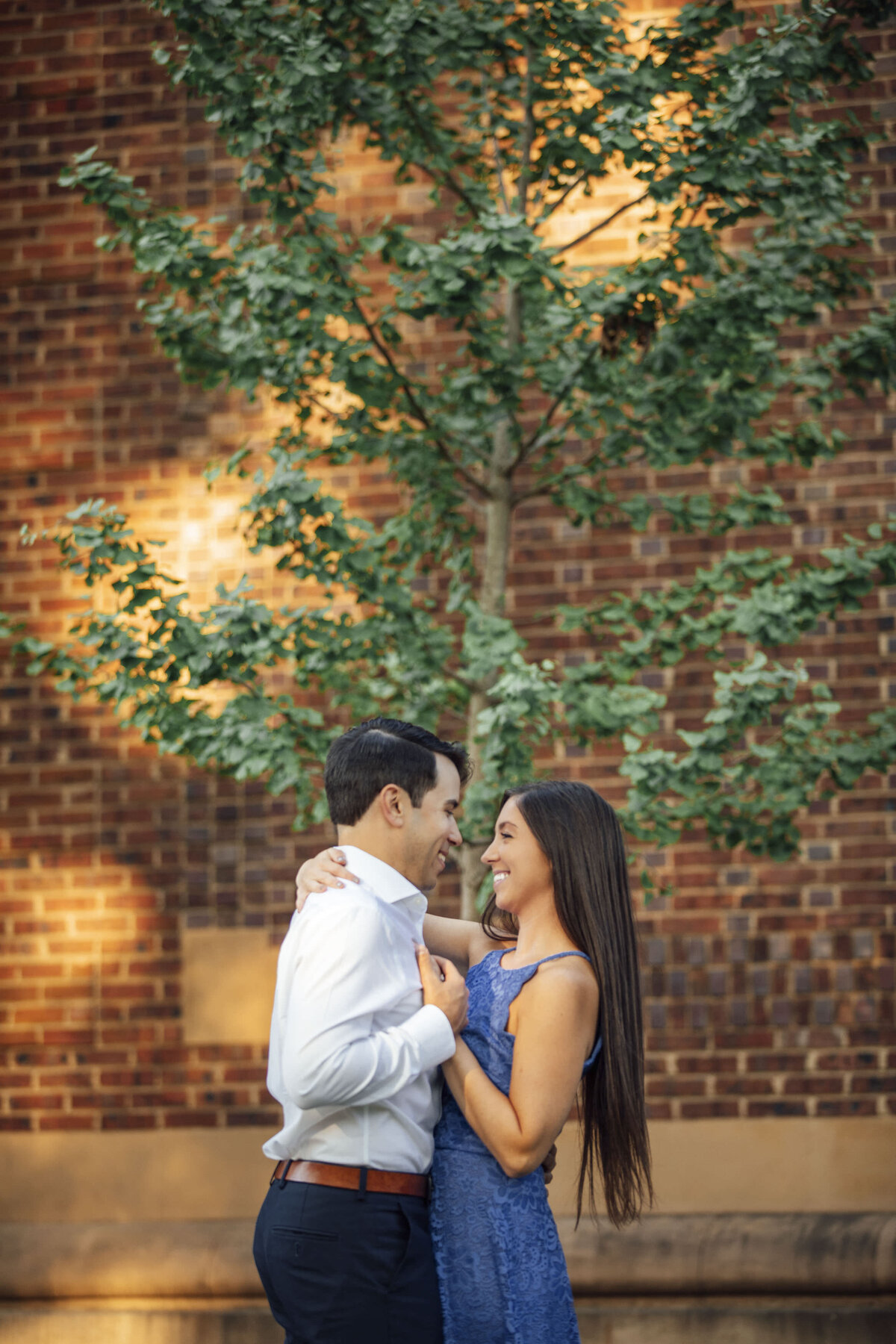 Couple dancing near brick building and tree during engagement shoot at Rutgers campus in New Brunswick New Jersey