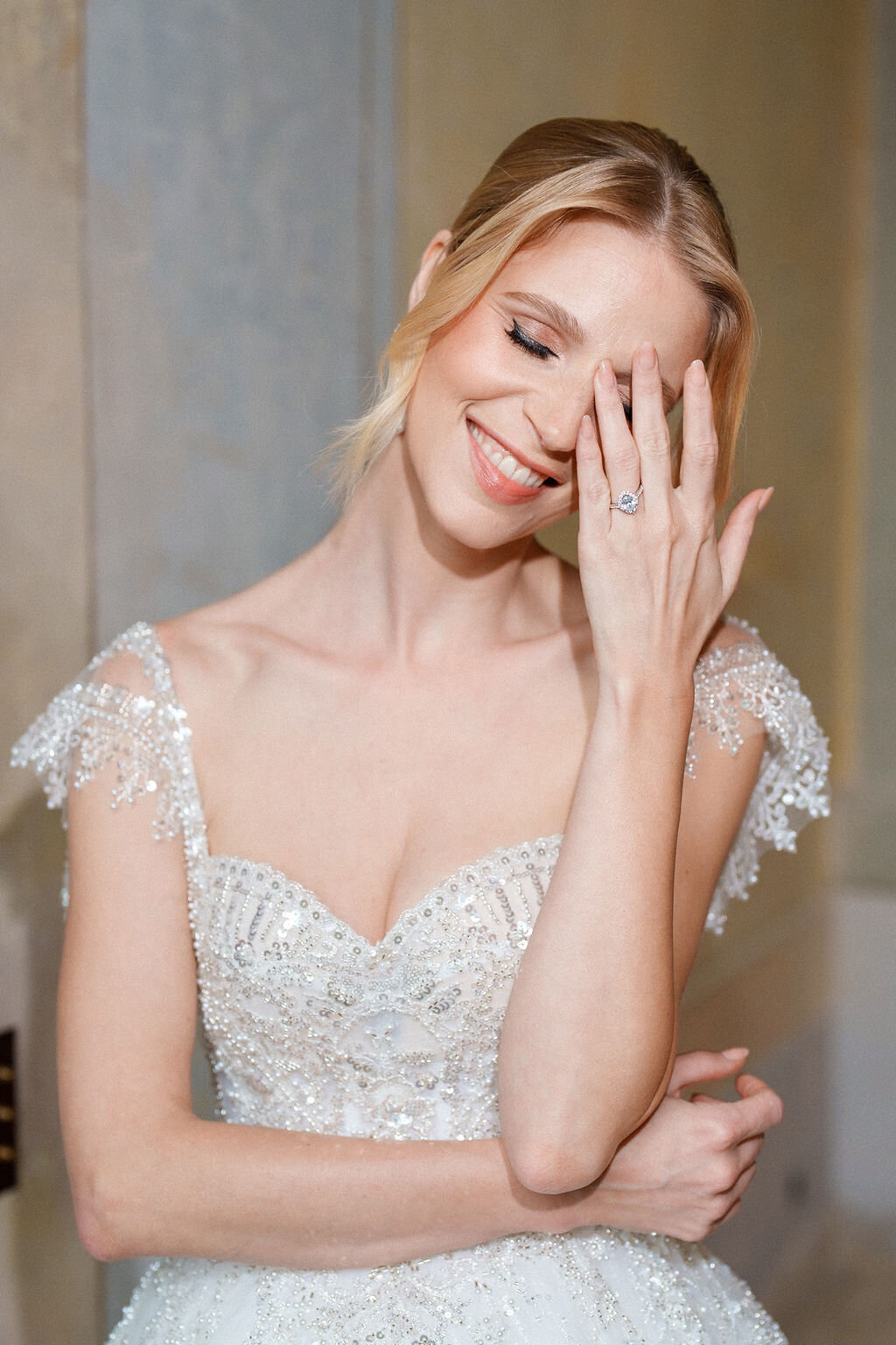 bride gently smiling while touching her face