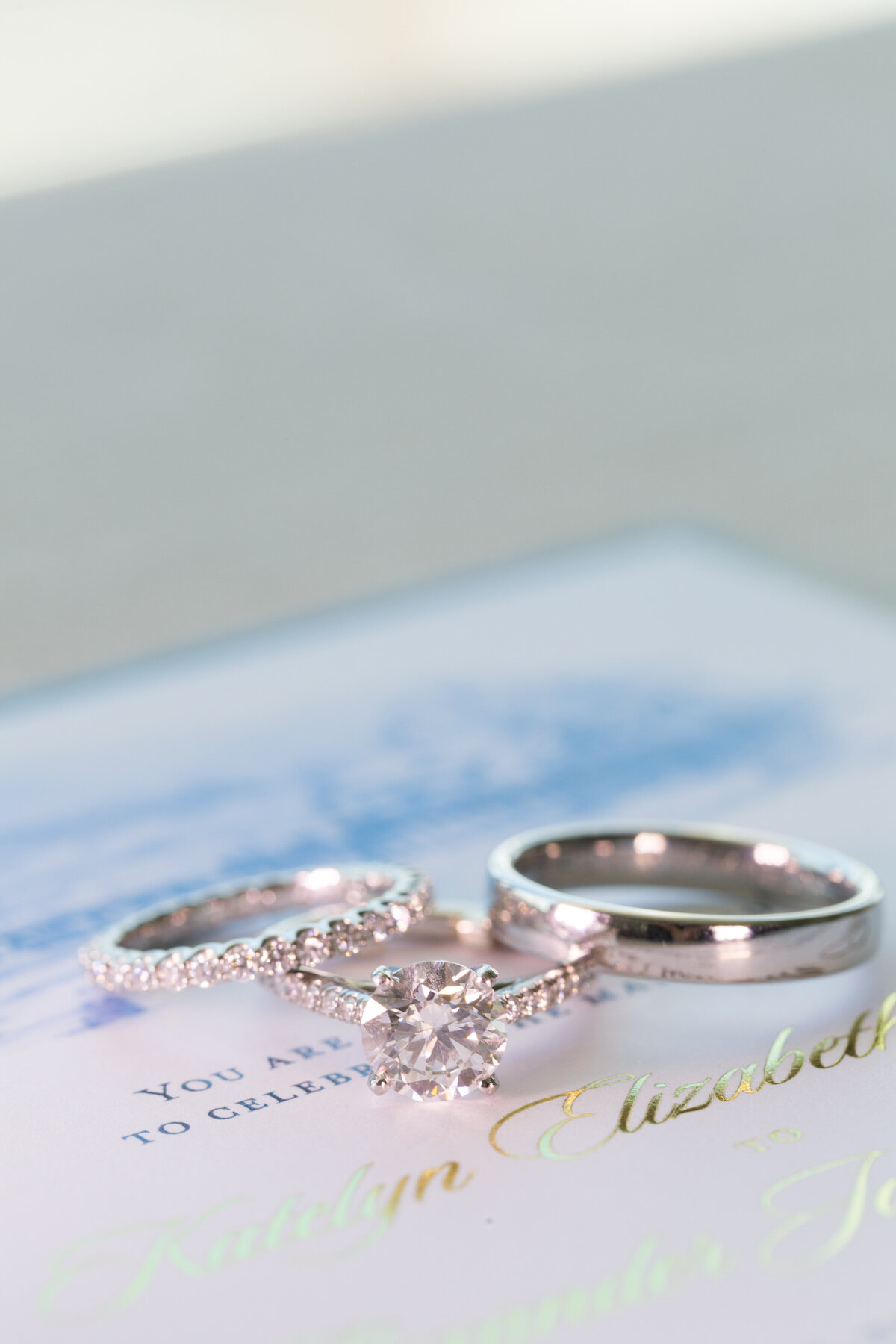 Wedding rings laid on top of a wedding invitation