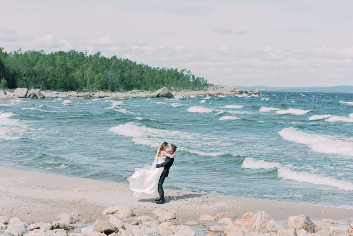 Wedding photographer Stockholm helloalora bride groom lifting bride on the beach wedding in Sundsvall