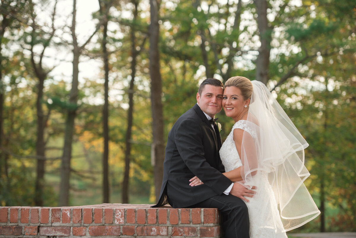 bride and groom posing outside of Heritage Club at Bethpage