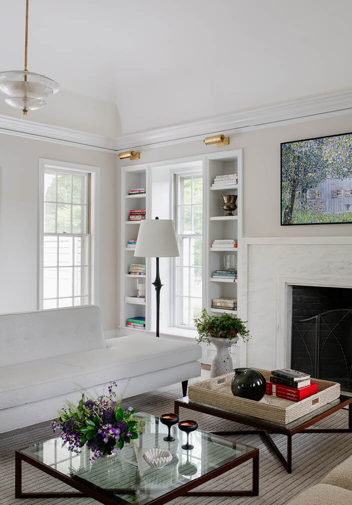 Admire the chic living room featuring Knoll chairs, walnut coffee tables, a Visual Comforts lamp, and an Arteriors pendant, combining elegance and modern design.