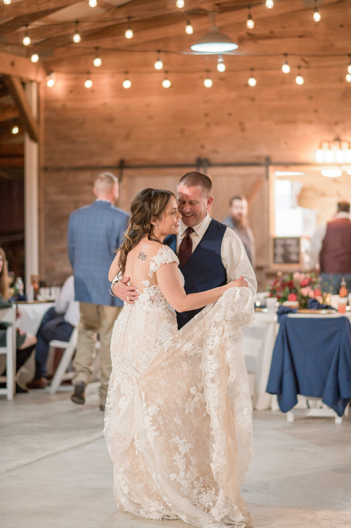 The bride and groom dance close together, enjoying their first dance as husband & wife