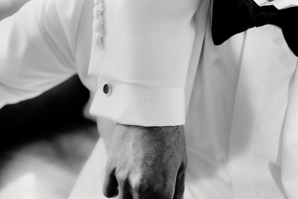 The groom's hand is showing outside his white polo with a black gauntlet in The Skylark, New York. Wedding Image by Jenny Fu Studio
