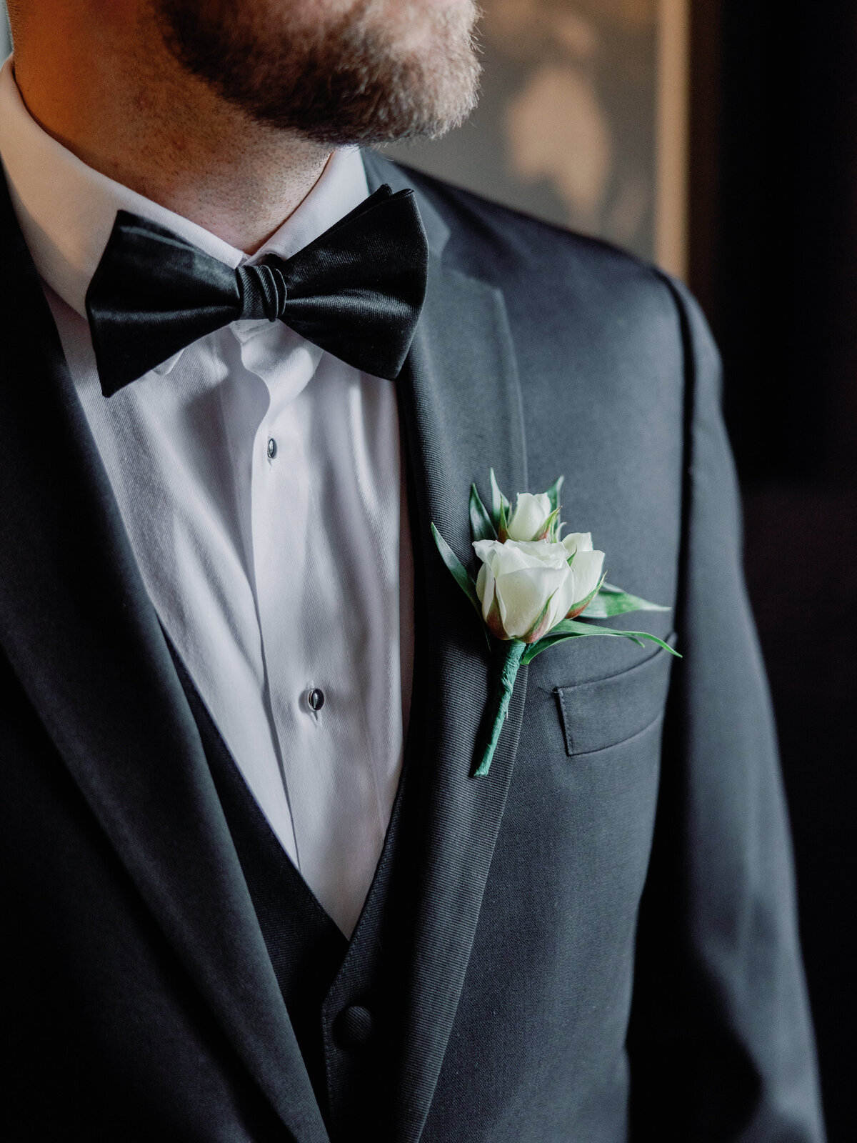A closeup of the groom's boutonniere pinned on his suit