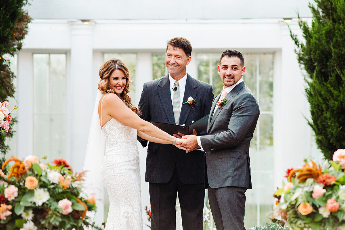 Bride and groom look at all of their guests during their wedding ceremony at Lionsgate.
