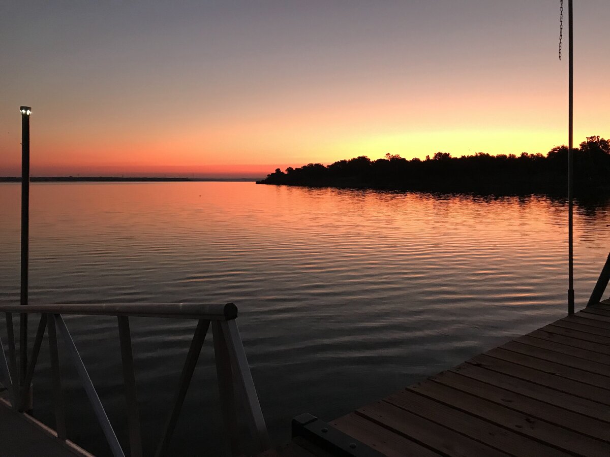View of Tradinghouse Lake with dock access at this 2-bedroom, 2-bathroom lakeside vacation rental home for 6 guests on Tradinghouse Lake with privacy access to a fishing dock and boat launch pad, ping pong table, gazebo, free wifi and free parking in Waco, TX.