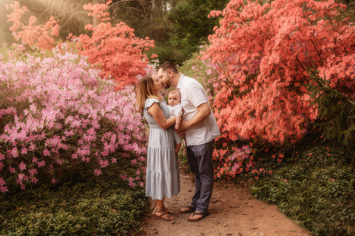 Parents embrace their baby during Family Photos at Biltmore Estate in Asheville, NC.