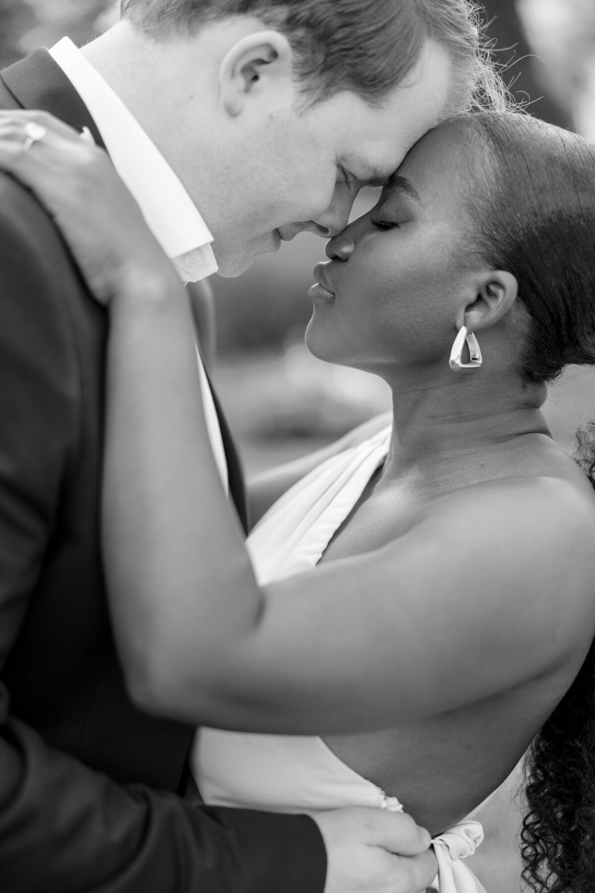 A couple shares a romantic moment in a formal garden along Michigan Avenue, surrounded by lush greenery and city charm.