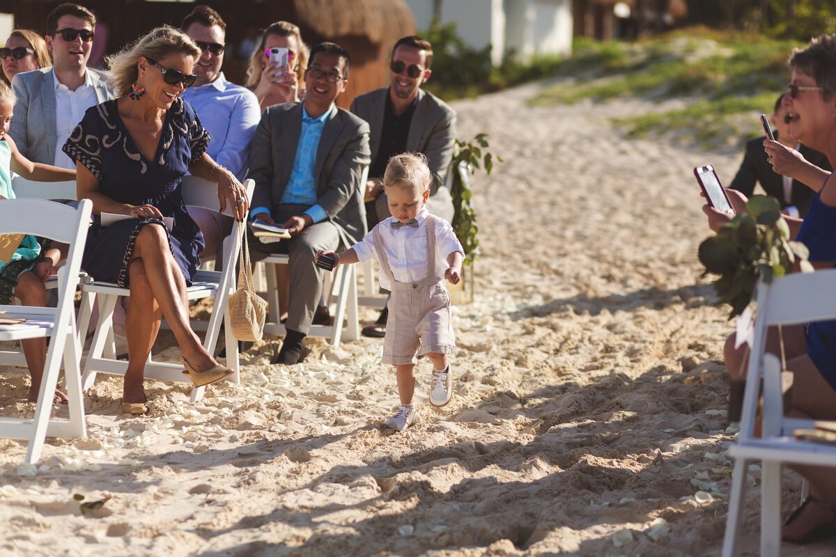 Ringbearer walking down aisle at beach wedding in Cancun