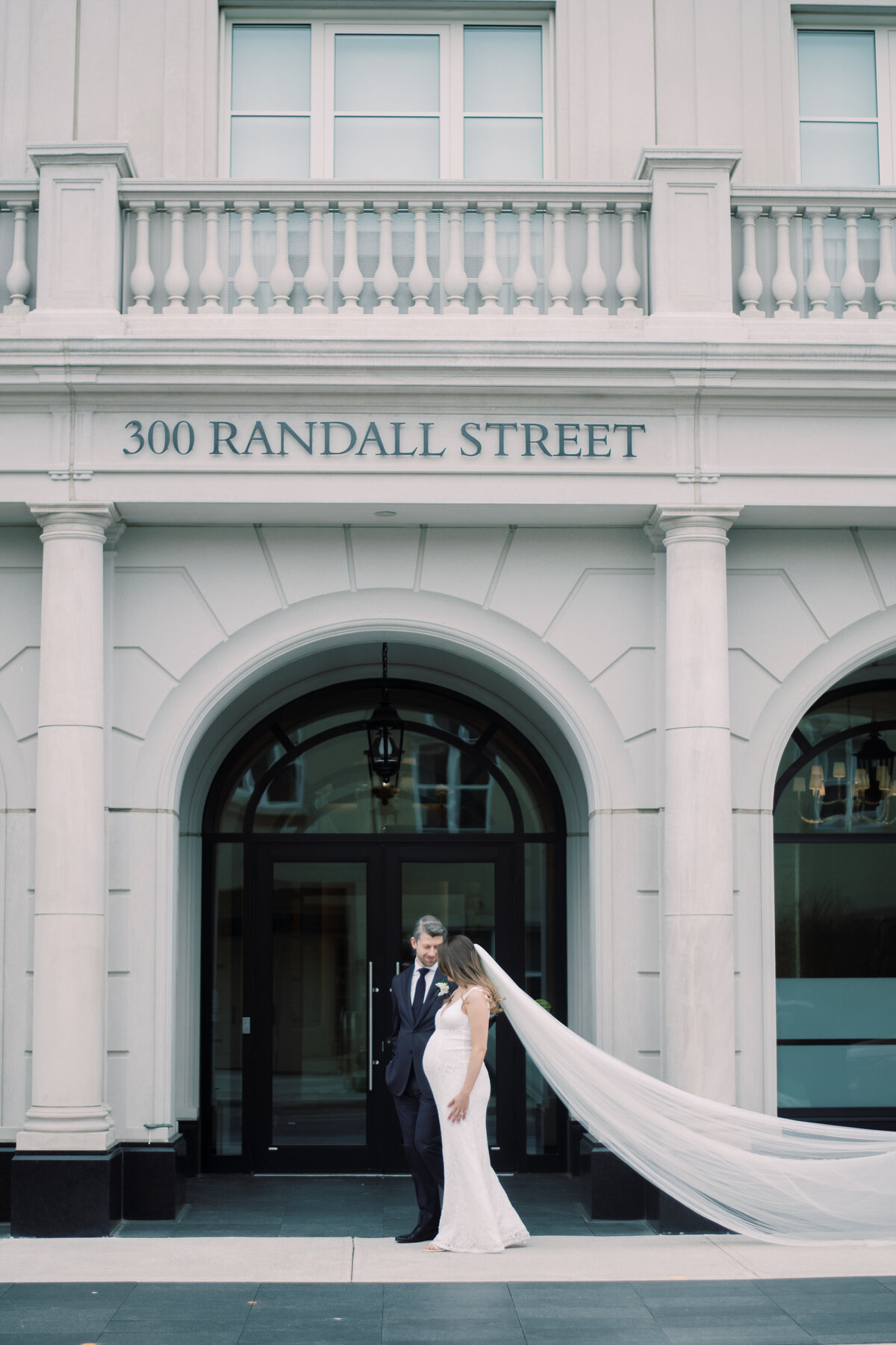 bride and groom walking with each other on Randall Street in Oakville.
