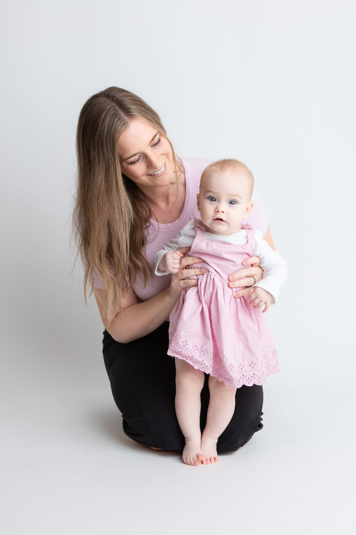 Edmonton mom and baby pose with white studio backdrop