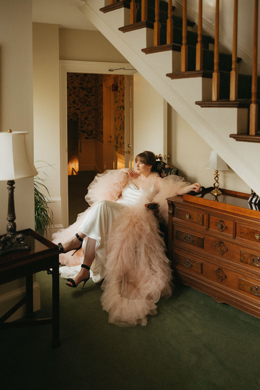 ride in a light pink robe, sitting in a chair with a soft smile