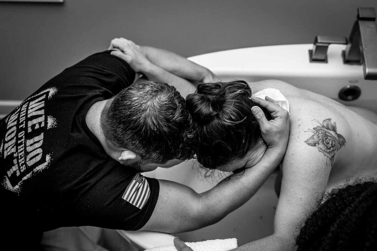 husband wife embrace during water birth