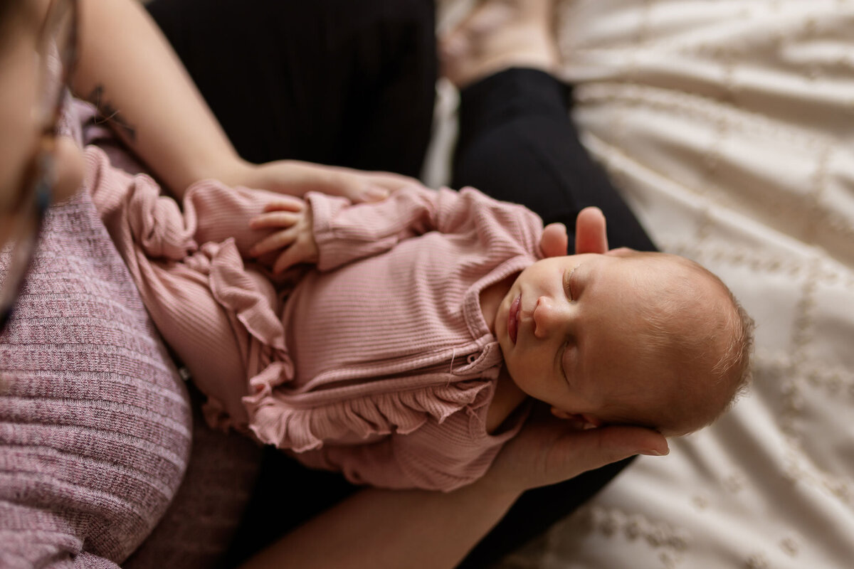 newborn baby girl sleeping in moms arms by nh newborn photographer Lisa Smith Photography