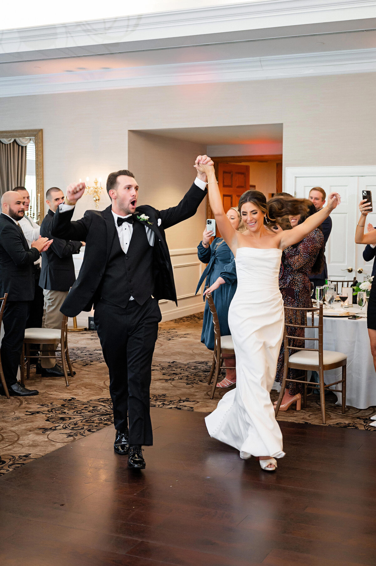 bride and groom cheering and partying as they enter their wedding reception at southpointe golf club