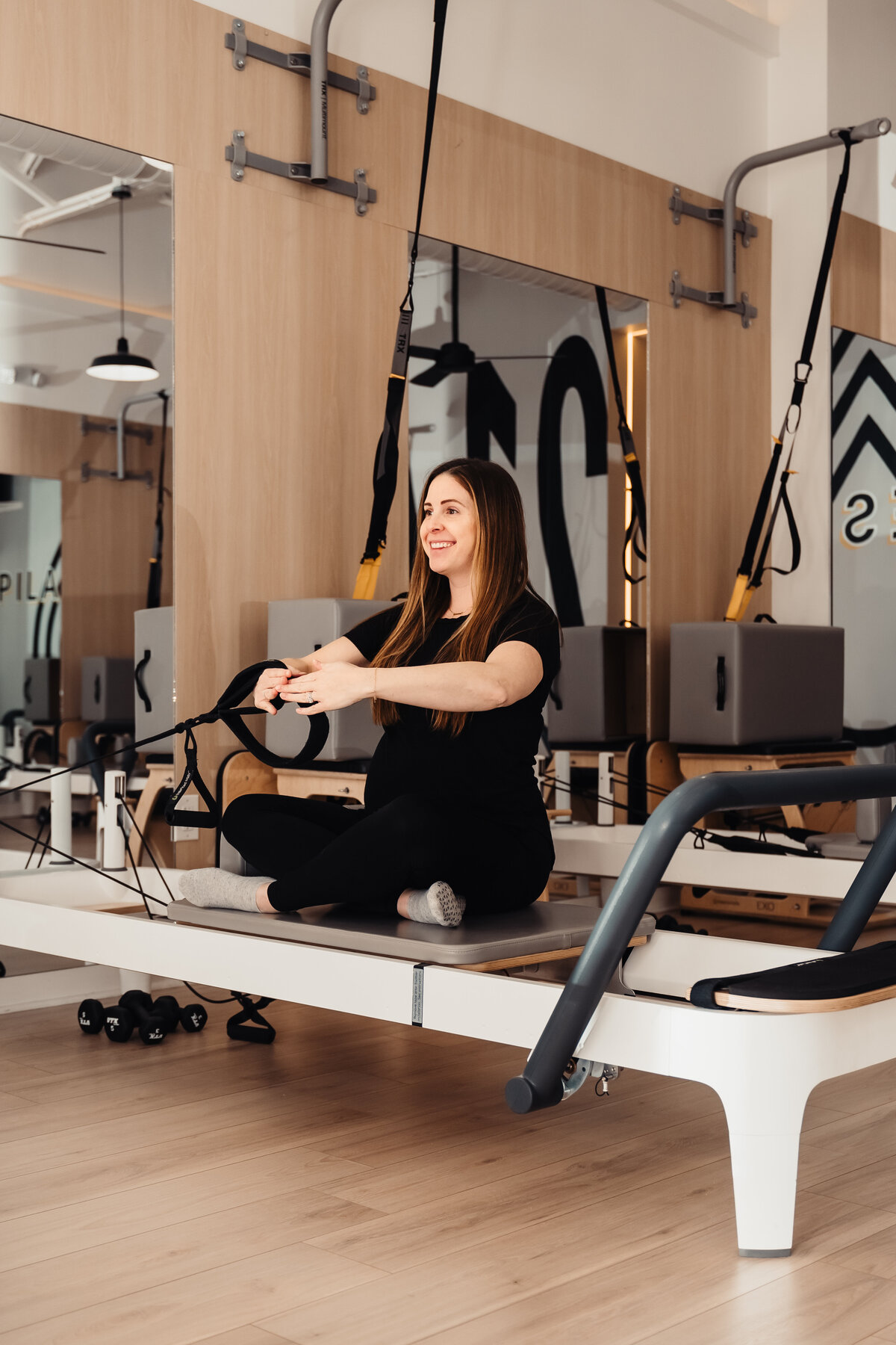 Pregnant mom on Pilates reformer in Dallas top Pilates studio.