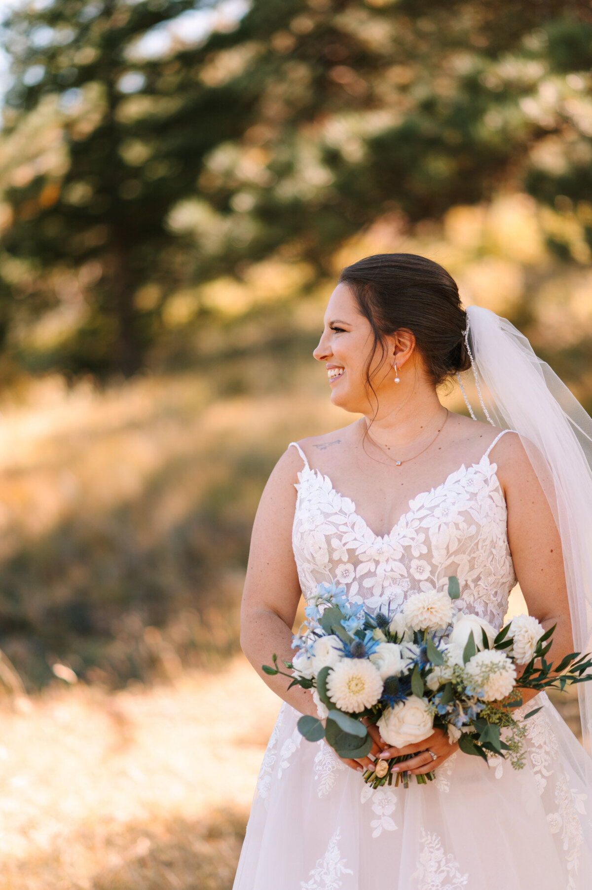 Meghan wearing her wedding dress and holding her wedding bouquet beautifully smiling