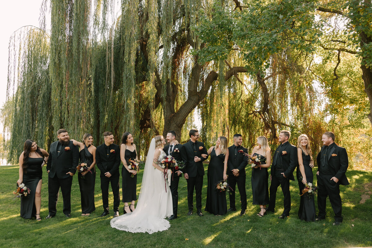 bride and groom holding hands with bridal party behind them